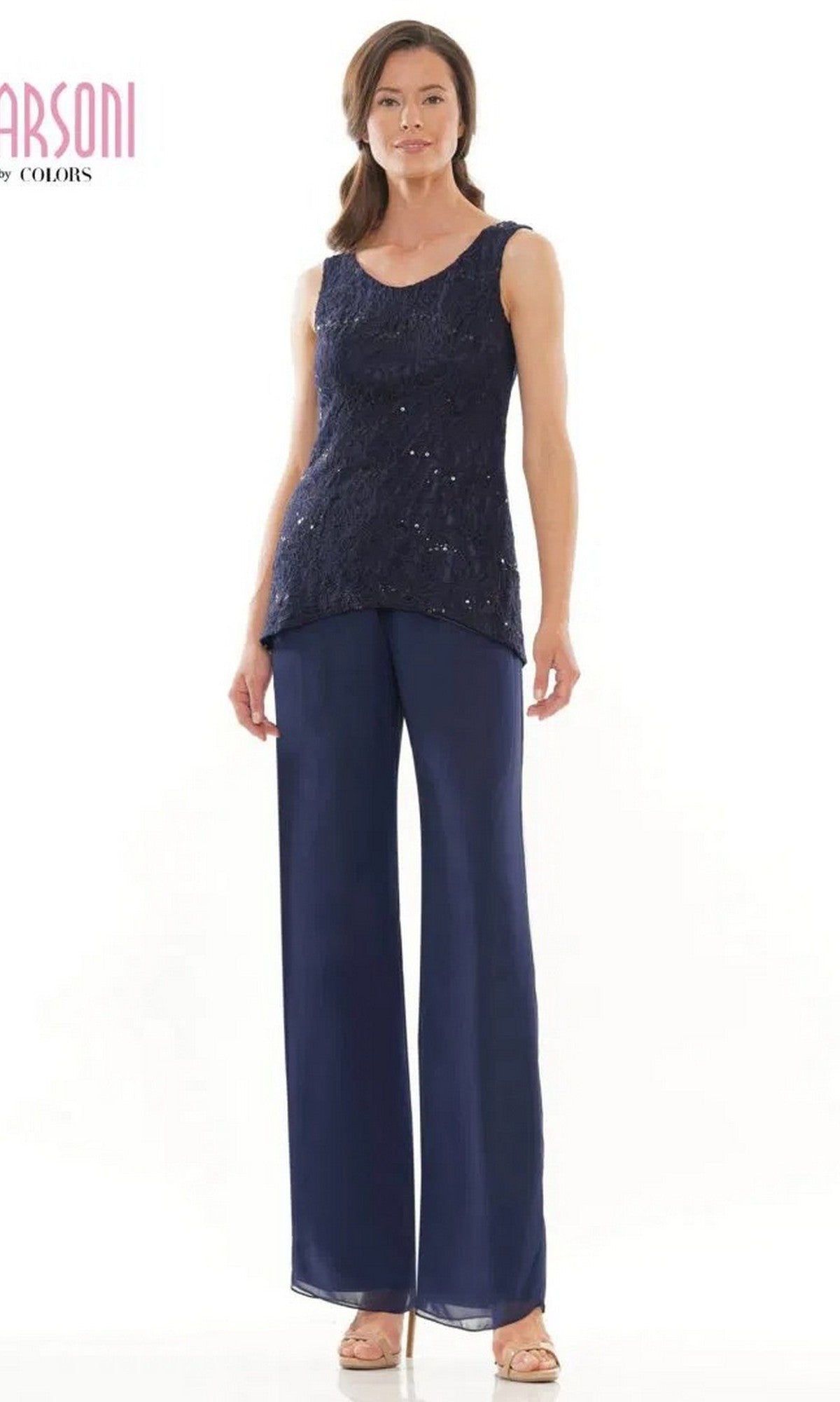 A woman poses against a white background wearing the Marsoni M303 long formal pantsuit—a sleeveless lace top with matching pants—paired with beige sandals.